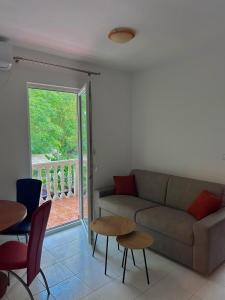 a living room with a couch and a table and chairs at Apartman Vujović Orahovac in Trstenik