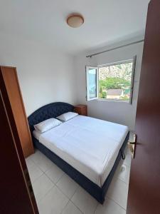 a bedroom with a bed and a window at Apartman Vujović Orahovac in Trstenik