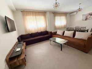 a living room with a couch and a table at Location meublée Martil in Martil