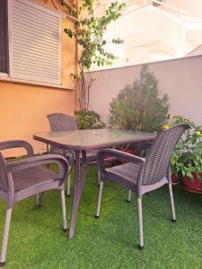 a table and chairs on a patio with grass at Maria's Garden Studio in Sarti