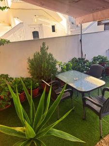 a patio with a table and chairs and plants at Maria's Garden Studio in Sarti