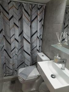 a bathroom with a white toilet and a sink at Maria's Garden Studio in Sarti