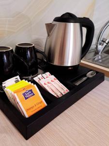 a black tray with a tea kettle and tea packets at Maria's Garden Studio in Sarti