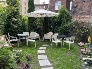 a patio with tables and chairs and an umbrella at Apartment Chorzow Center in Chorzów