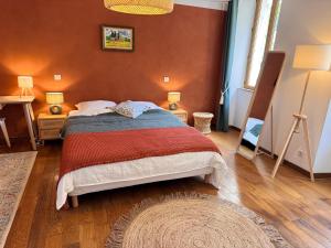a bedroom with a bed with a red wall at Portail Sainte Marie in Montbrun-les-Bains +36 photos