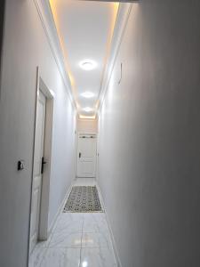 a corridor with a white hallway with a ceiling at Um yousef house in Alexandria