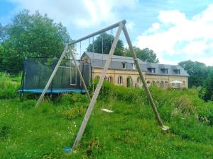 a swing set in a field in front of a building at La mouche de mai in Fécamp