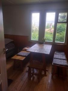 a room with a table and two benches and windows at Domek v přírodě Hradec Králové in Hradec Králové