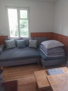 a blue couch in a room with a window at Domek v přírodě Hradec Králové in Hradec Králové