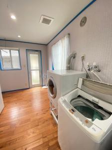 a washing machine in a bathroom with a sink at Guest House SOL in Hiraisomachi