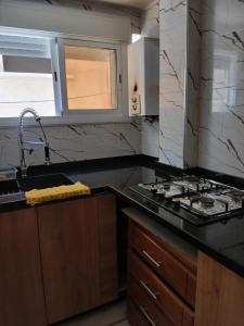 a kitchen with a sink and a stove at Casa youssef 2 in Asilah