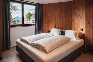 a large bed in a room with a window at Aparthotel Bacher in Bressanone +230 photos