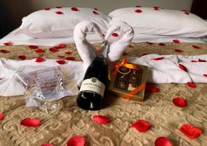 a bottle of wine and two swans with hearts on a bed at Pousada Bello Outono in Canela