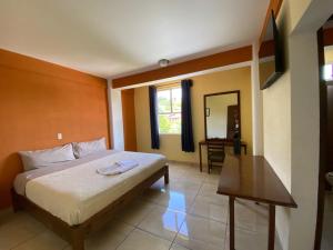 a bedroom with a bed and a table and a mirror at Hotel Casa Rus in Comitán
