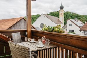 a table on a balcony with a view of a church at Gäste-Haus Rösch in Wiesent