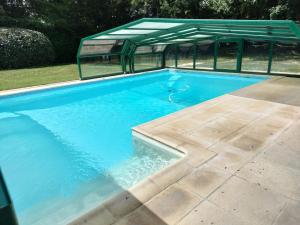 a large swimming pool with a green roof at Les Mulotières in Olivet
