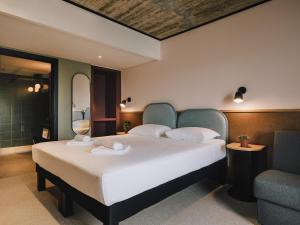 a bedroom with a large white bed and a chair at ibis Styles ST Pauls Bay Malta in St. Paul's Bay +120 photos