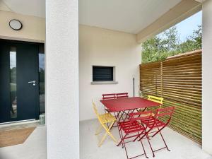 a red table and chairs on a patio at Escapade Gîte Seryse in Châtillon-sur-Broué