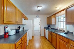 a kitchen with wooden cabinets and a white refrigerator at Serenity House - 1006 Ave 26th in Vero Beach