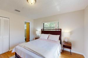 a white bedroom with a large bed and a window at Serenity House - 1006 Ave 26th in Vero Beach +27 photos