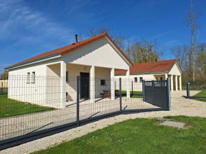 a white building with a fence in front of it at Escapade Gîte Seryse in Châtillon-sur-Broué