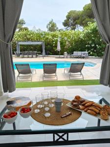 a table with a tray of food on it next to a pool at Menorca Villa Marbella in Son Parc