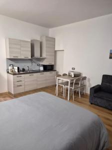 a bedroom with a bed and a table and a kitchen at Malpensa Sleep & Go in Somma Lombardo
