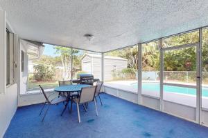 a dining room with a table and chairs and a pool at Serenity House - 1006 Ave 26th in Vero Beach
