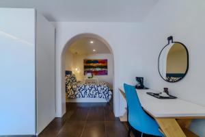 a room with a bed and a desk and a mirror at Villa De Marcos in Arona