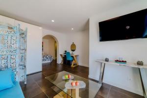 a living room with a table and a tv on the wall at Villa De Marcos in Arona