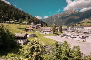 a town in the mountains with cars parked in a parking lot at Landhaus am Hügel in Bad Gastein