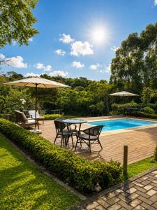 a patio with a table and chairs next to a pool at Celeiro in Campina Grande do Sul +17 photos