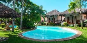 a swimming pool in front of a resort at Le Zahir Lodge in Ambatoloaka