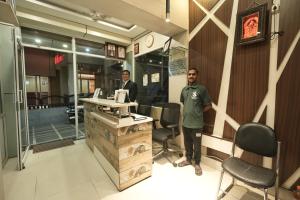 two men standing in the front of a restaurant at Subhash Hotel in Prayagraj