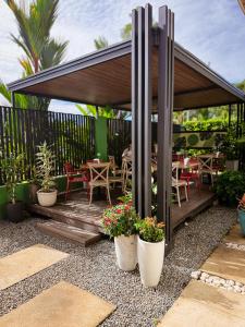 a pavilion with tables and chairs and potted plants at Hotel Oasis AYA FE in San Isidro de El General