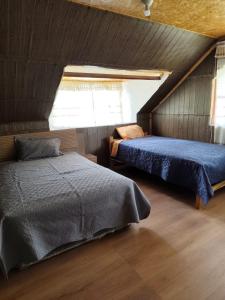 a bedroom with two beds in a attic at Yanesh Haus habitaciones Oxapampa in San Antonio