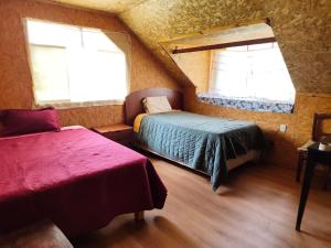 a bedroom with two beds and two windows at Yanesh Haus habitaciones Oxapampa in San Antonio