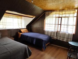 a bedroom with two beds and two windows at Yanesh Haus habitaciones Oxapampa in San Antonio