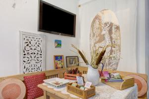 a living room with a table with a vase and a tv at Agriturismo Odorizzi in Tassullo