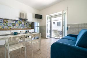a kitchen and a living room with a blue couch at Casa Canzatora in Sperlonga