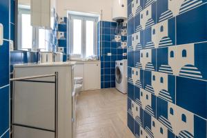 a kitchen with blue and white tiles on the wall at Casa Canzatora in Sperlonga +46 photos