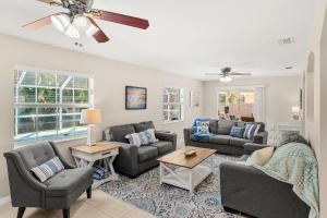 a living room with couches and a ceiling fan at Paradise Vacay in Sebastian