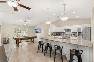 a kitchen with a bar with stools and a table at Paradise Vacay in Sebastian