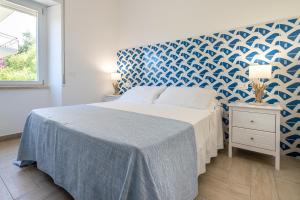 a bedroom with a bed with a blue and white wall at Casa Canzatora in Sperlonga