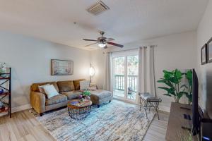 a living room with a couch and a ceiling fan at Cypress Cove 111 in Melbourne