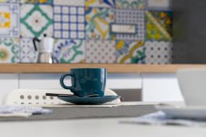 a green coffee cup sitting on a table at Casa Canzatora in Sperlonga