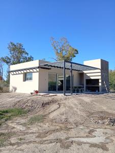 a white house with a driveway in front of it at Quincho Lelita in Zonda