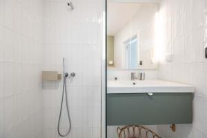 a white bathroom with a shower and a sink at Rivara Rooftop By ALGARTUR in Cabanas de Tavira