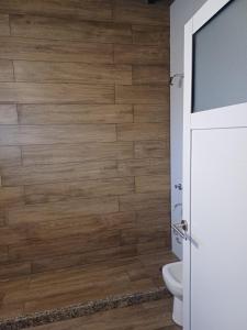a bathroom with a toilet and a wooden wall at Quincho Lelita in Zonda +11 photos