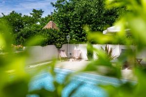 a swimming pool with two chairs and a gazebo at La Demeure du Bord'Ô in Lagruère +58 photos